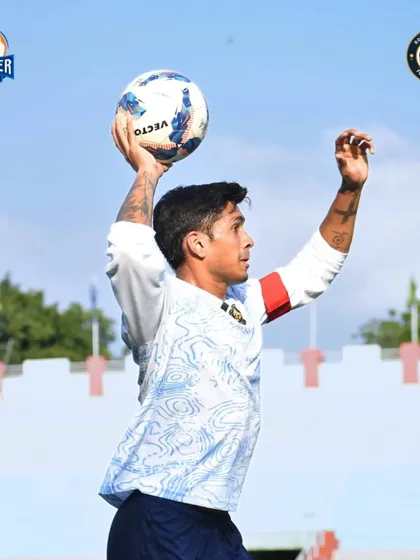 A player prepares for a throw-in against the backdrop of the stadium, ready to put the ball back in play.
