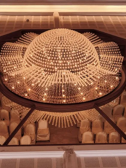 Sometimes you need to see the bigger picture. This wide-angle shot from a Pondicherry wedding captures the couple in a moment of solitude, dwarfed by the magnificent scale and grandeur of their venue's chandelier.