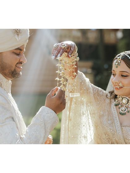 A playful and sweet moment with the kalire. This tradition becomes a beautiful photo opportunity, showcasing the bride's intricate jewelry and the couple's joyful connection.