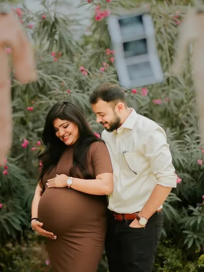 A happy couple moment during their outdoor pregnancy announcement shoot. The props in the background add a charming, rustic feel to the celebration.