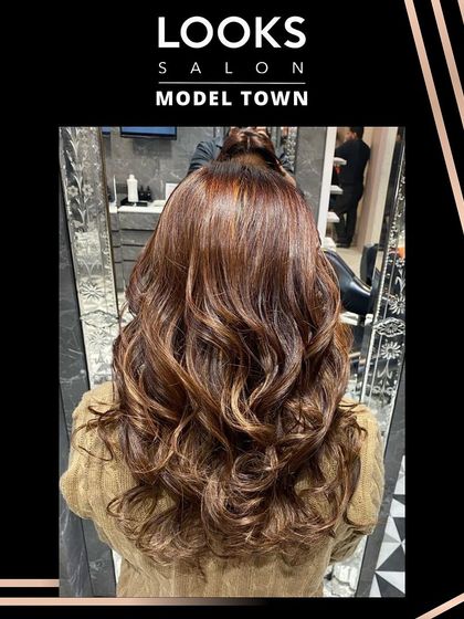 The final result of the reddish-brown hair color, styled into bouncy curls that show off the vibrant tones.
