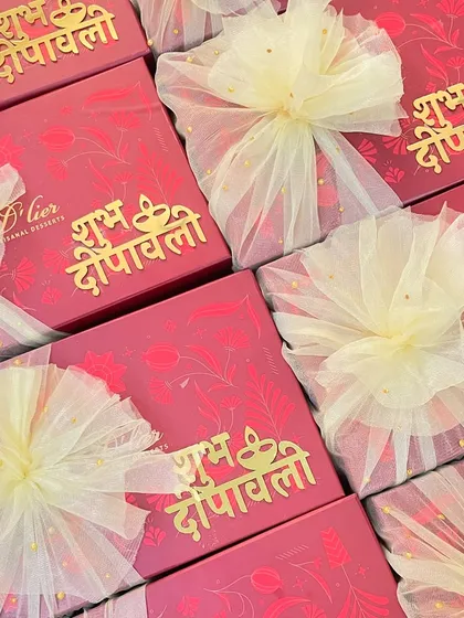 A collection of our vibrant red Diwali gift boxes, adorned with "Shubh Deepawali" in golden script and finished with delicate tulle bows.