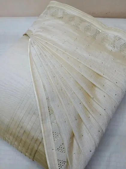 This elegant off-white saree with delicate sequin work has been pleated for a flawless drape. I handle embellished fabrics carefully to protect the handiwork.