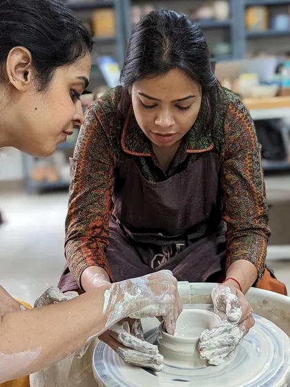 Showing a student how to shape the clay is a key part of our hands-on teaching approach.