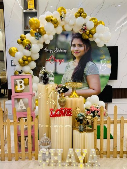 We can make your celebration extra personal. For this event, we designed a setup around a large custom portrait of the mom-to-be, framed by a white and gold balloon arch, a picket fence, and light-up letters spelling her name.