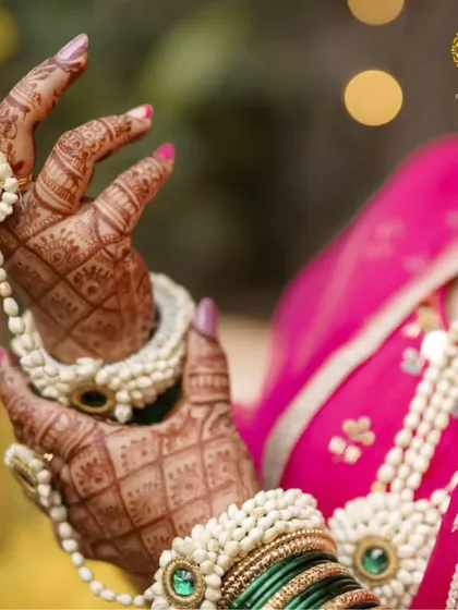 A close-up of the hathphool from the baby shower set. The intricate weaving of mogra buds and the central green stone detail showcase the fine craftsmanship.