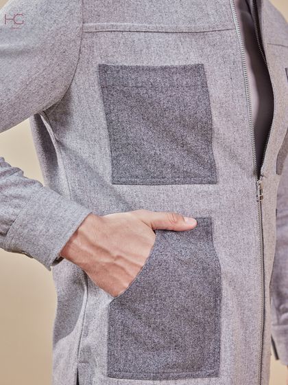 A detail shot of the grey shacket, focusing on the contrasting texture of the large patch pockets. It’s these details that blend ease with a modern edge.