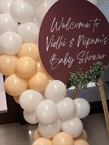 A simple yet elegant welcome sign for a baby shower, featuring a modern circular design and a small balloon accent.