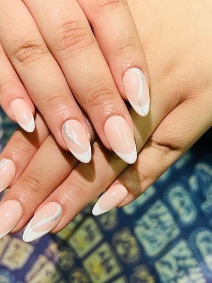 An elegant almond-shaped French manicure with abstract white swirls for a soft, modern feel.