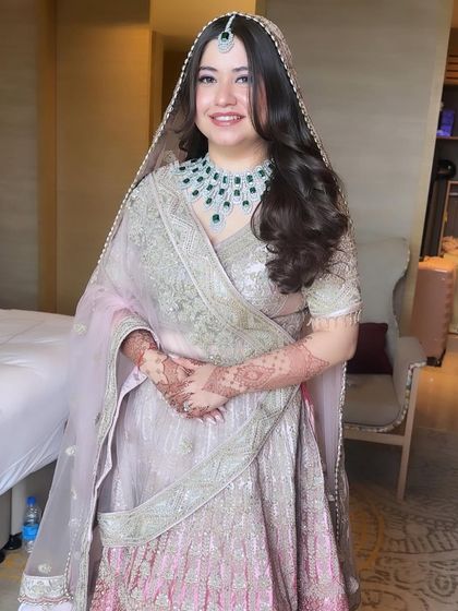 A full view of Priyal's minimalistic and beautiful bridal look. The soft pastel colors of her outfit are complemented by a fresh, glowing makeup application that lets her natural beauty shine.