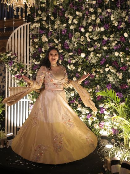 A joyful twirl in front of a beautiful floral backdrop at a Sangeet. My outfits are always chosen to match the grandeur and theme of the wedding decor.