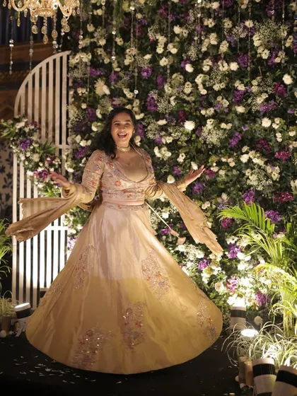 A joyful twirl in front of a beautiful floral backdrop at a Sangeet. My outfits are always chosen to match the grandeur and theme of the wedding decor.