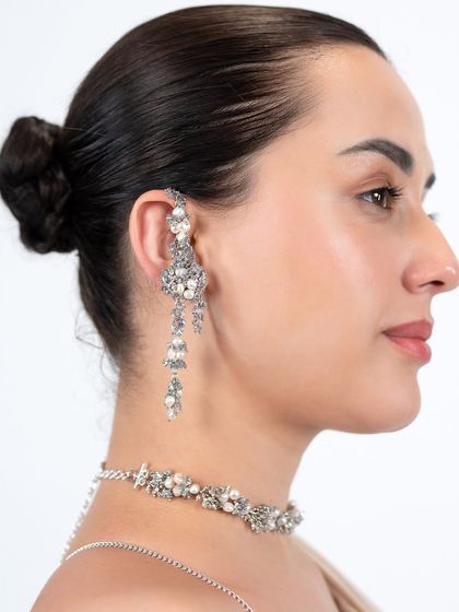A silver-toned earcuff with cascading details, paired with a matching choker for a glamorous evening look.