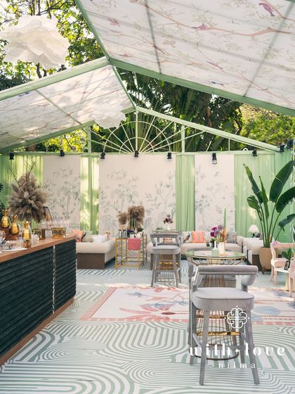 An overview of our 'Conservatory' themed baby shower. The custom-built structure with botanical print ceilings, sage green walls, and modern furniture creates a chic, light-filled, and serene environment for celebration.