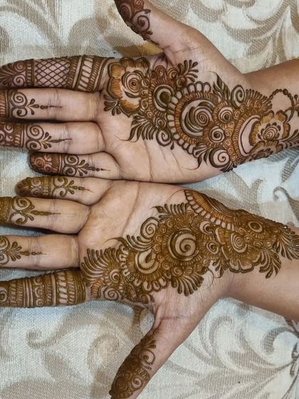 A simple Arabic-style bail or vine pattern for guests. This design flows gracefully across the back of the hand and is a popular choice for a quick and elegant look.