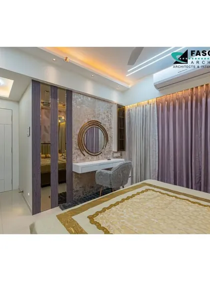 This bedroom in Seawoods includes a chic vanity nook with a round mirror set against a textured wall. The combination of soft purples and grays creates a calming and sophisticated palette.