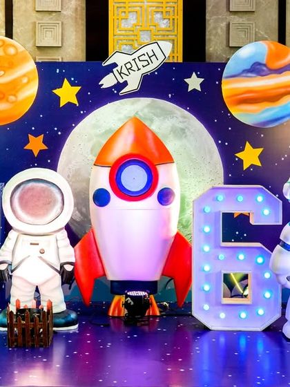 A detailed space-themed stage with planets, a rocket ship, an alien, an astronaut, and a light-up number '6'.