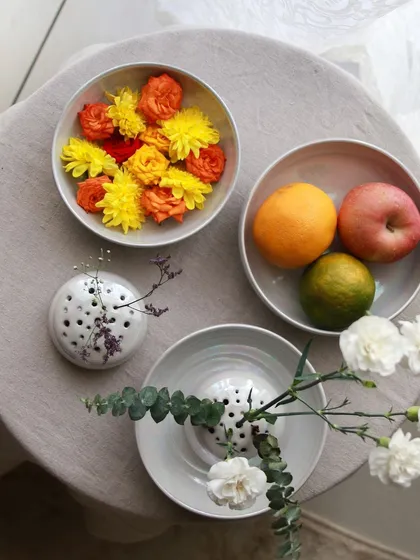 A variety of flower frog vases and bowls from the 'Celebrations' collection, perfect for creating beautiful floral centerpieces.