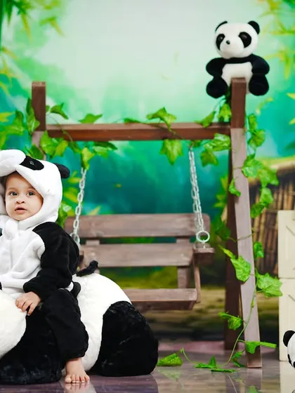 This little panda takes a ride on a bigger panda, creating a sweet and playful scene.