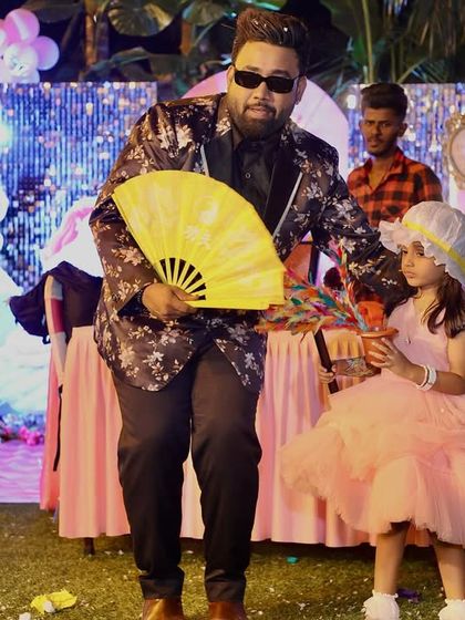 A charming moment with a young assistant during a fan production trick. Her beautiful dress and the colorful stage made for a picture-perfect memory.