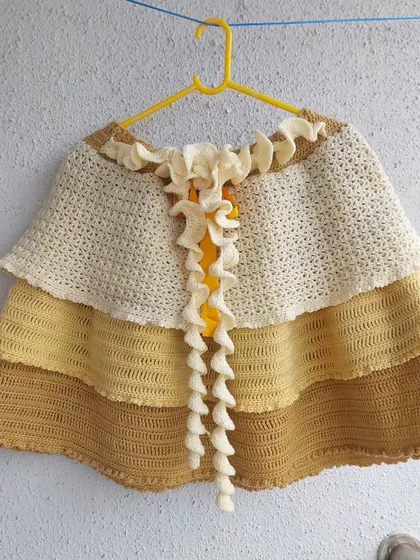 A hanging view of the Nereid Skirt, showcasing the layered construction and curly ties.