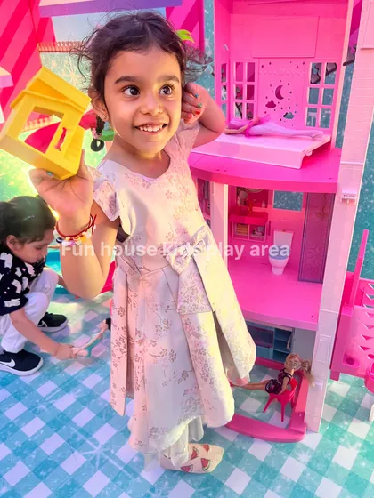 A happy child immersed in imaginative play with our Barbie Dream House rental. This is part of our pretend play collection, designed to spark creativity and storytelling at birthday parties.
