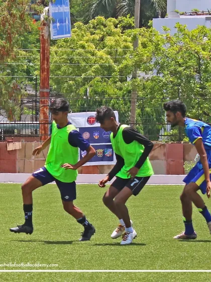 Three players in bright green bibs intensely compete for the ball during a small-sided game at the Spain trial event.