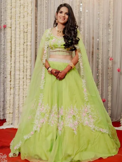 The full view of this bride's fresh and fun lime green engagement lehenga. The makeup is kept light and glowing, perfect for the occasion.