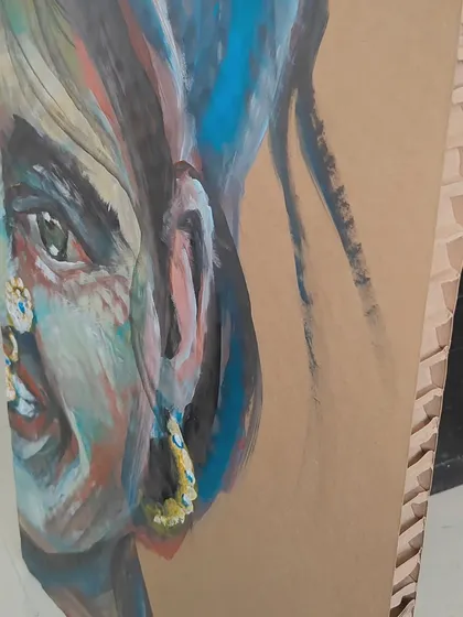 Another angle of "Colors," highlighting the joyful expression and the use of bold blues and reds against the natural cardboard.
