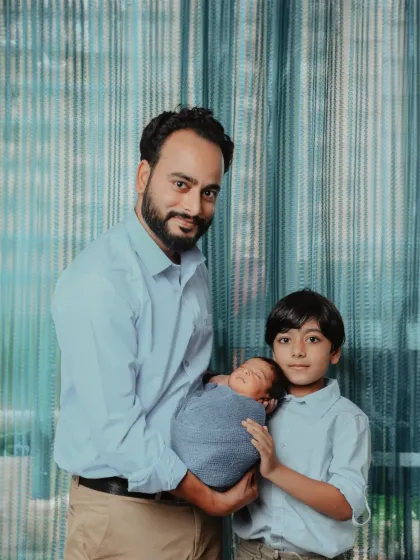 A family united. Here, a proud father and big brother welcome the tiniest new member, creating a portrait of love that spans generations.