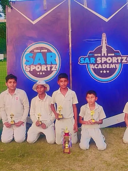 Our coach stands with a group of young winners, all holding their well-deserved trophies.
