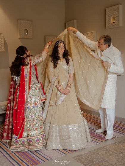 The parents placing the veil on their daughter, a beautiful and symbolic gesture of their blessing.