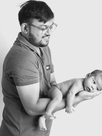 The same beautiful portrait of a father and his newborn, presented in timeless black and white to emphasize the emotion and connection.