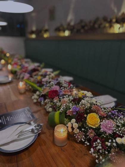 A close-up of the beautiful floral table runner, showing the mix of roses, carnations, and baby's breath that added a touch of elegance to the party.