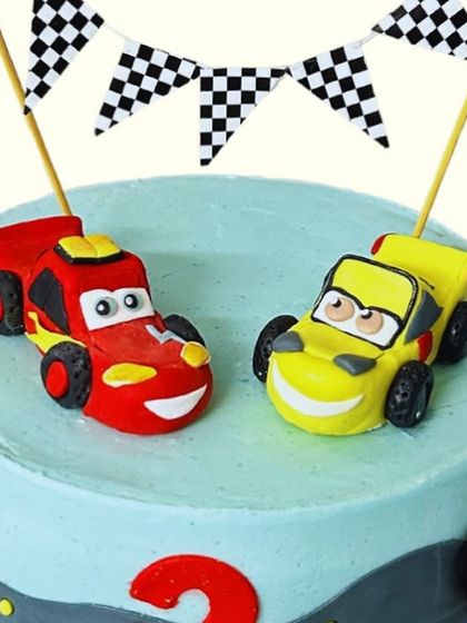 A close-up of the handmade fondant Lightning McQueen and Cruz Ramirez toppers. Creating these characters with personality is one of my favourite parts of making kids' cakes.