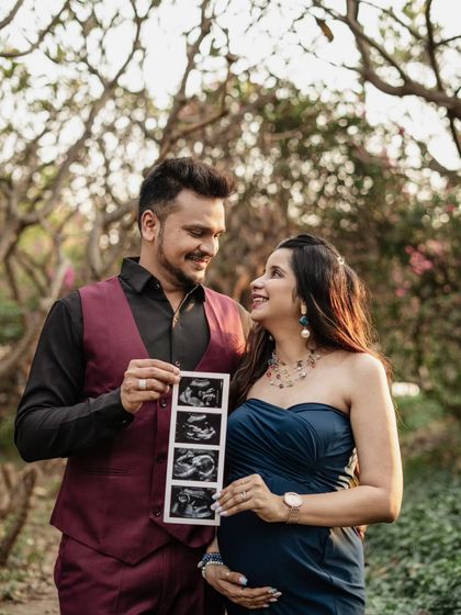 Sharing the big news with a smile! This happy couple holds up their ultrasound scan during their outdoor maternity session. It's a classic and joyful way to announce their pregnancy.
