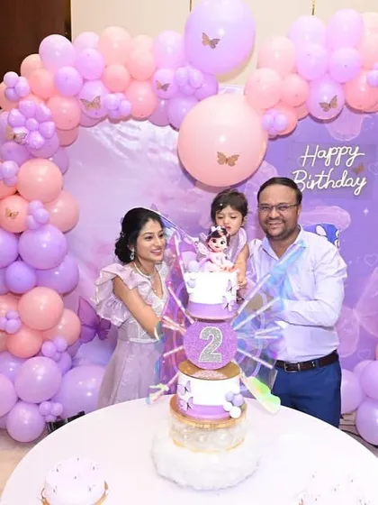 The family lights the candles on the butterfly cake, ready to make a wish.