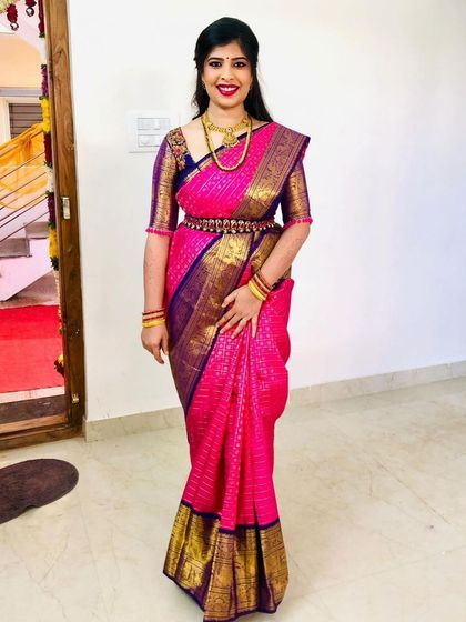 A forever favorite look for a treasured client. This vibrant pink and violet Kanchipuram silk saree is paired with a custom-designed blouse, creating a timeless and elegant ensemble for her special occasion.