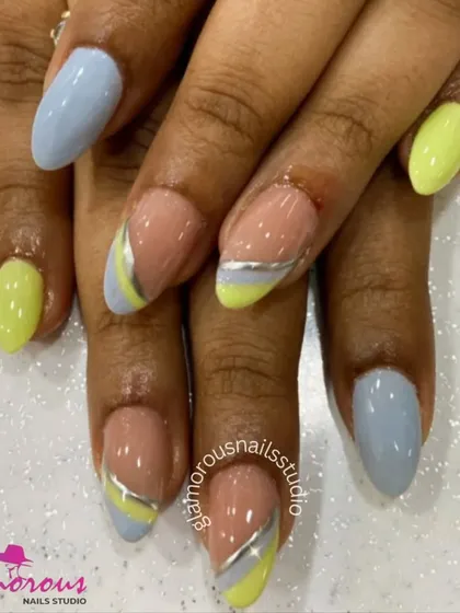 A fresh and modern color combination. This set features solid pastel blue and yellow nails, paired with accent nails that have a chic, color-blocked design with a silver dividing line.