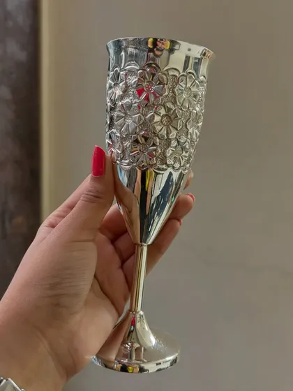 A hand holding our pure silver wine glass with a floral embossed pattern. This is a perfect gift for weddings, anniversaries, or for anyone who appreciates fine barware.