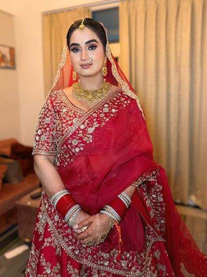 A full portrait of this ultimate red bridal glam. The makeup is balanced, with defined eyes and a soft lip, letting the bride's natural beauty shine through.