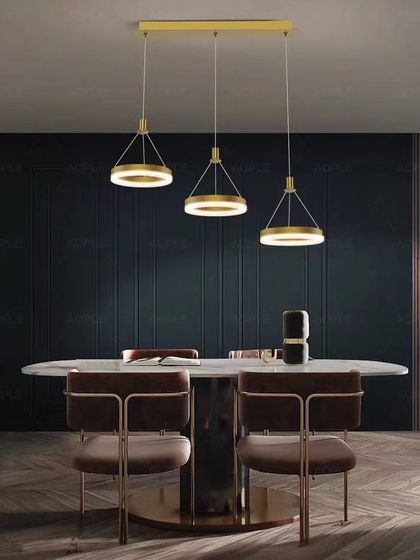 A set of three ring pendants over a dining table. This clean and modern setup provides great task lighting with a sophisticated look.