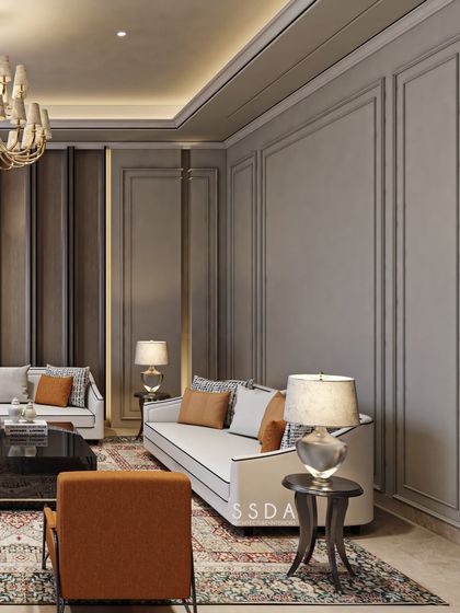 The neoclassical mouldings on the walls add a layer of architectural detail that elevates this living room. The soft grey color keeps the look modern and serves as a neutral canvas for the furniture.