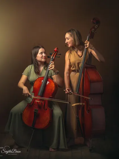 Music is the thread that connects this mother and daughter. This portrait, featuring Petra on the double bass and Maja on the cello, is a unique storybook image celebrating their shared passion. It’s a powerful representation of a bond deepened through art.