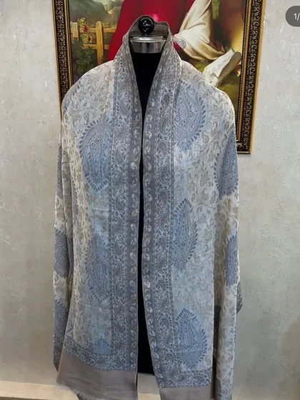 A light-coloured pashmina with a subtle blue and grey paisley design. This is a very versatile scarf that can be worn year-round.