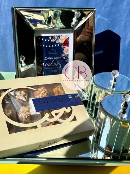 Another look at our elegant wedding invitation set. The mirrored tray and glass jars add a touch of luxury, paired perfectly with a custom-framed invitation and a box of premium baklava.