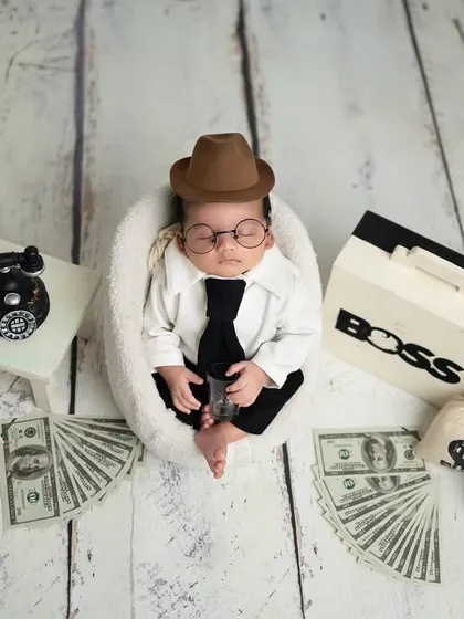 Let's have some fun. My 'Boss Baby' theme is always a hit with parents. Complete with a tiny suit, tie, and fun props like a briefcase and money bags, it’s a playful way to capture your little one's big personality.