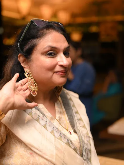 A guest at one of our private showcases admiring a pair of grand, chandelier earrings. These events are a fantastic opportunity to try on our most spectacular occasion wear pieces.