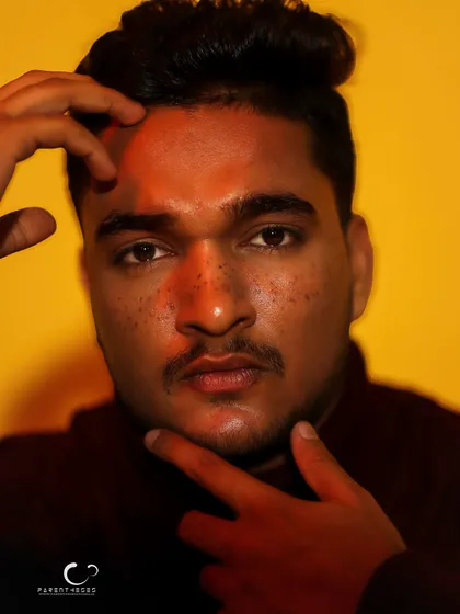 A close-up portrait with dramatic lighting. The red light across his face creates a split-tone effect, adding intrigue and artistry.