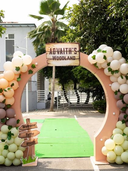 A grand entrance arch for Advaith's woodland party. The arch is decorated with organic balloon garlands in soft, earthy tones, setting a rustic and elegant mood for the celebration.